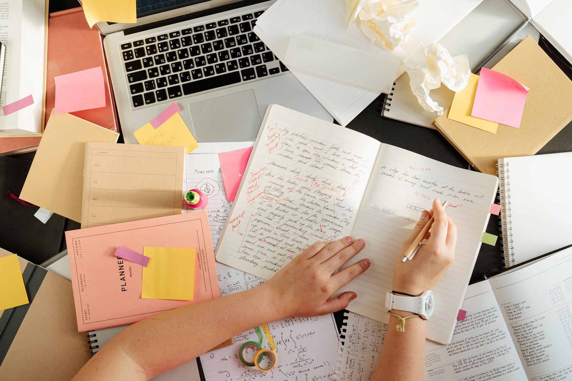 Schreibtisch mit Lernnotizen, Notizbuch und Laptop bei der Prüfungsvorbereitung